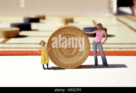 Donna e bambina in piedi di fronte a un gigantesco Checkers board game Foto Stock