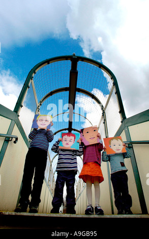 Bambini maschere di contenimento nella parte anteriore delle loro facce su un ponte Foto Stock