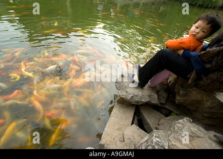 Suzhou il Giardino Lingering (Liu Yuan) bambino guardando goldfish in stagno Foto Stock