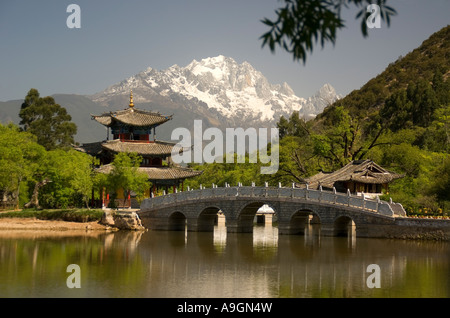 Lijiang's Black Dragon Pool con Luna abbracciando Pavilion e Ponte della cinghia con Jade Dragon Snow Mountain in background Foto Stock