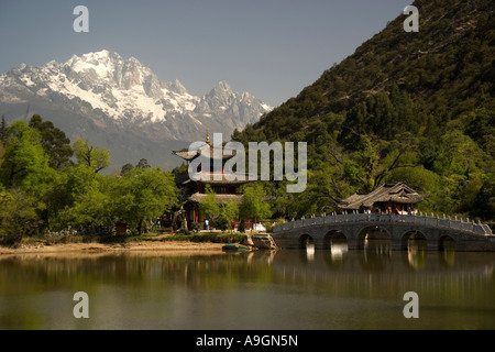 Lijiang's Black Dragon Pool con Luna abbracciando Pavilion e Ponte della cinghia con Jade Dragon Snow Mountain in background Foto Stock