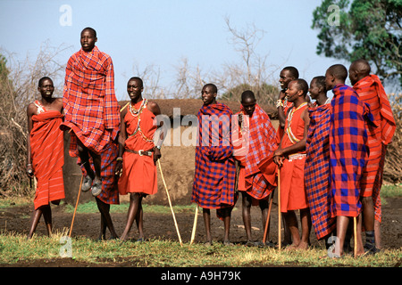 Un gruppo di Masai uomini facendo una danza tradizionale nel loro villaggio (chiamato manyatta) nel Masai Mara in Kenya. Foto Stock