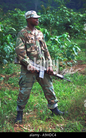 Soldato africana con AK47 fucile, guardia di confine di una miniera d'oro da minatori illegali che invadono la miniera di scavare in cerca di oro in Africa occidentale Foto Stock