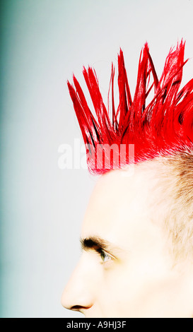 Vista laterale di un giovane uomo con un'acconciatura Mohican rossa e lati rasati. Foto Stock