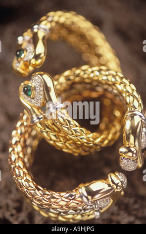 Il diamante e la Gioielleria in oro, coppia di bracciali con tessuto bianco e oro giallo con smeraldi. Foto Stock