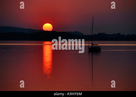 Tramonto con barca a vela oltre il Chiemsee Baviera Germania Foto Stock