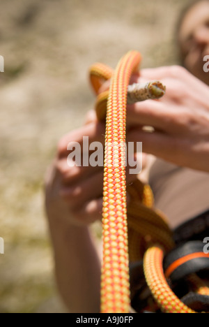 Femmina di rocciatore cravatte un follow-through-la figura di otto nodi su arrampicate su roccia elettrico Foto Stock