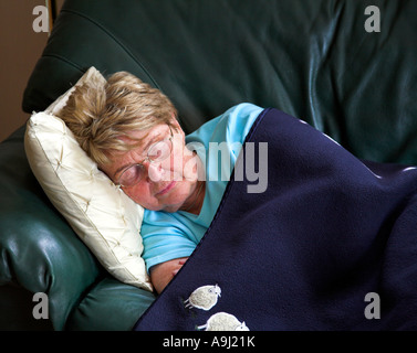 Donna anziana dorme sul divano Foto Stock