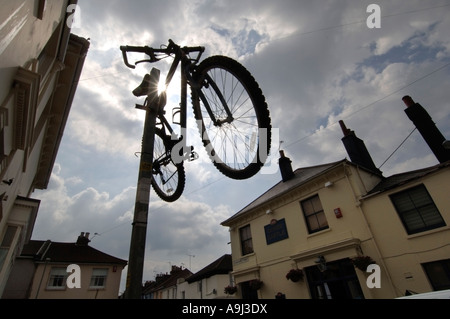 Un Raleigh Mountain bike è fissato sulla parte superiore di un parcheggio polo di restrizione su una strada della città. Foto Stock