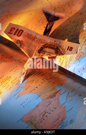 Aeroplano fatta di pound note su open atlas Foto Stock