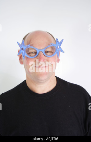 Uomo di mezza età in 40s o 50s novità da indossare occhiali stella sorridente Foto Stock