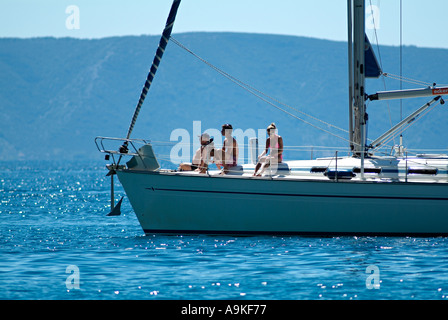 Yacht con persone lounging sul ponte di vele nel porto di Makarska, Dalmazia, Croazia. Foto Stock