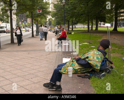Senzatetto che dorme su una panchina in un parco pubblico, Atlanta, Georgia, Stati Uniti. Foto Stock