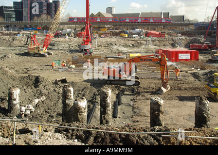 Cantiere affollato fa pieno uso delle macchine per il seminterrato foundation palificate & Associati opere di massa treni DLR oltre Foto Stock