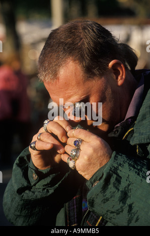 New Caledonian Market, concessionario che utilizza un anello per controllare la qualità di un anello Bermondsey Square Antiques Market Londra. Mercato del venerdì commercianti 1990 UK Foto Stock