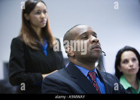 Uomo di affari e donne guardando e ascoltando con attenzione Foto Stock