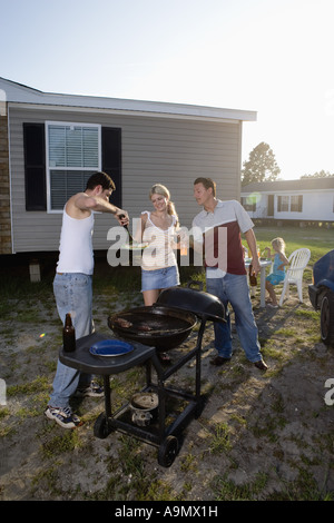 Collare blu famiglie godendo un cookout nella parte anteriore del rimorchio home Foto Stock