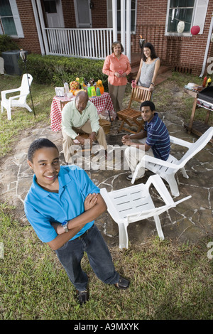 Ritratto di African ragazzo adolescente con la famiglia e gli amici in background Foto Stock