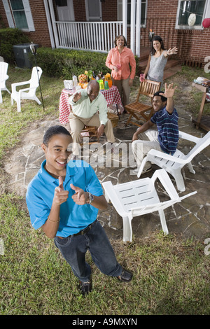 Ritratto di African ragazzo adolescente con la famiglia e gli amici in background Foto Stock