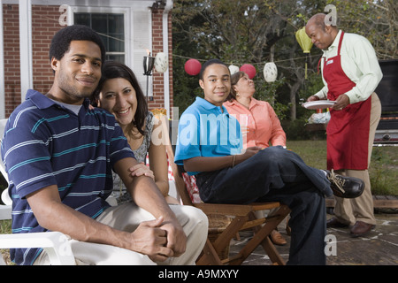 Interracial coppia e famiglia godendo di backyard barbeque Foto Stock