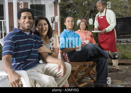 Interracial coppia e famiglia godendo di backyard barbeque Foto Stock