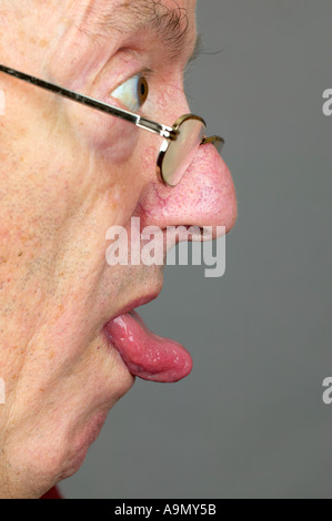 Uomo anziano verticale di chiudere con la lingua fuori Foto Stock