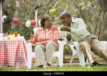 Coppia matura conversando accanto al tavolo da picnic Foto Stock