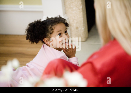 Giovane ragazza in pigiama cercando fino a sua madre in primo piano Foto Stock