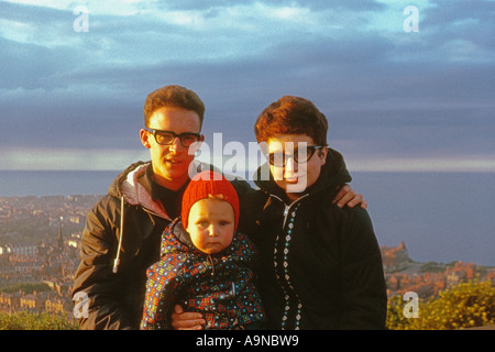 Giovane famiglia caucasica in giacche caldi a Oliver's Mount con Scarborough e il Mare del Nord in lontananza. Intorno al 1960. Archivio Foto Stock