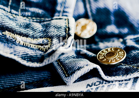 Button vola di un vecchio paio di blue jeans denim Foto Stock
