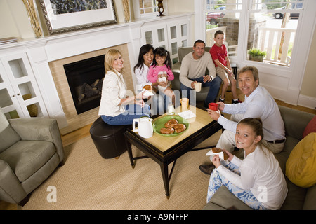 La famiglia e gli amici di fare colazione insieme in salotto Foto Stock