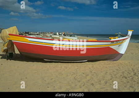 ARMACAO DE PERA Algarve Portogallo Europa Può colorata rosso giallo bianco barca di pesca sulle sabbie dorate della spiaggia di Praia de isole Pescadores Foto Stock