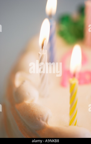 Acceso candele su una torta di compleanno Foto Stock