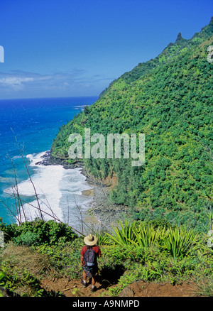 Escursionista sul Kalalau Trail in Kauai guarda giù alla spiaggia Hanakapiai Foto Stock