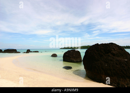 Rocce nere sulla spiaggia su Ko Kham isola della Thailandia Foto Stock