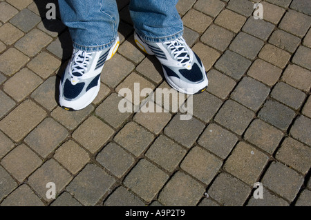 Nuovi formatori su un uomo che indossa jeans blu Foto Stock