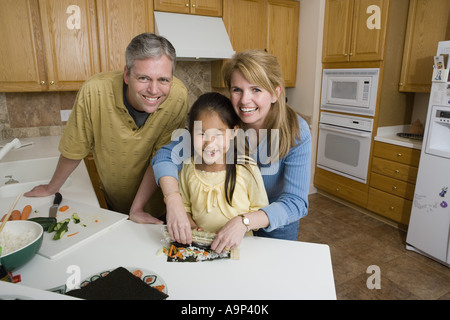 Ritratto di una famiglia in cucina rendendo sushi Foto Stock