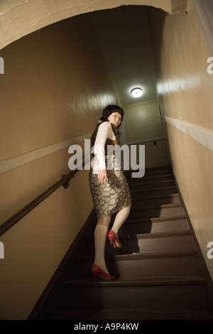 Vista di una giovane donna asiatica al fondo della scala Foto Stock