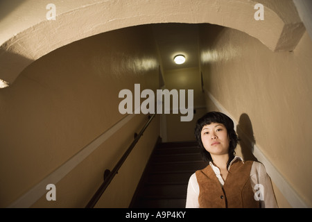 Vista di una giovane donna asiatica al fondo della scala Foto Stock
