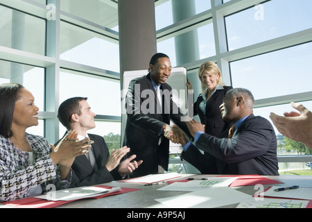 Colleghi di lavoro ad applaudire in una riunione Foto Stock