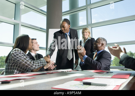 Colleghi di lavoro ad applaudire in una riunione Foto Stock