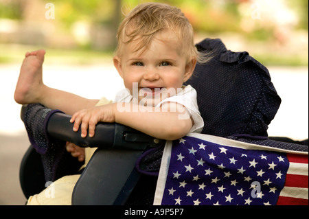 Bambina in passeggino con bandiera americana Foto Stock