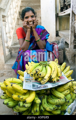 Donna indiana la vendita di banane provenienti da un cesto su strada Foto Stock