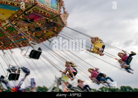 Bambini godendo fairground ride swing Foto Stock