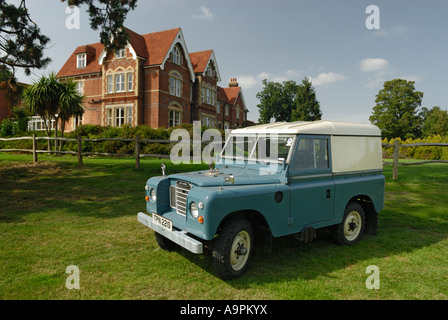 Molto originale 1977ish Landrover Series 3 Hardtop su un campo con una grande casa di campagna in background. In Europa il REGNO UNITO Inghilterra Surrey. Foto Stock