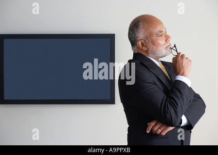 Ritratto di un uomo d'affari alla ricerca riflessivo Foto Stock