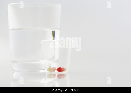 Pillole con un bicchiere di acqua Foto Stock