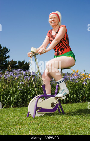 Senior donna adulta in sella ad una bicicletta Foto Stock
