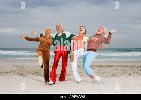 Quattro senior adulti che esercitano sulla spiaggia Foto Stock