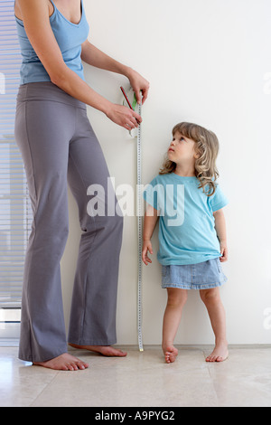 Madre figlie di misurazione altezza Foto Stock